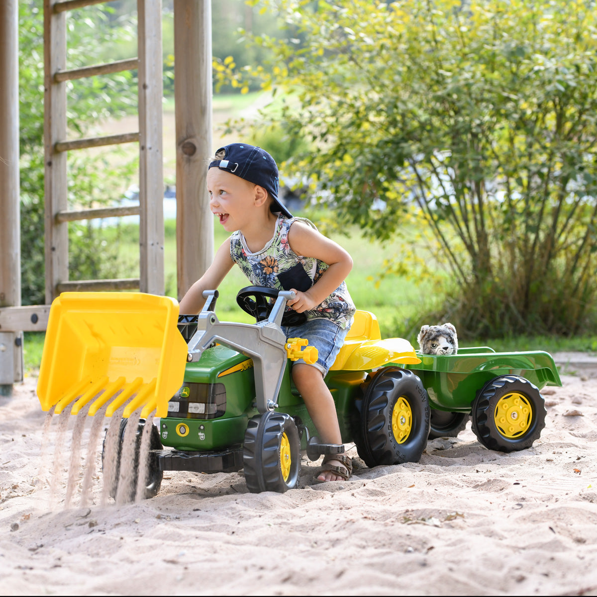 lifestyle image of child riding JD ride on vehicle with functional front loader 