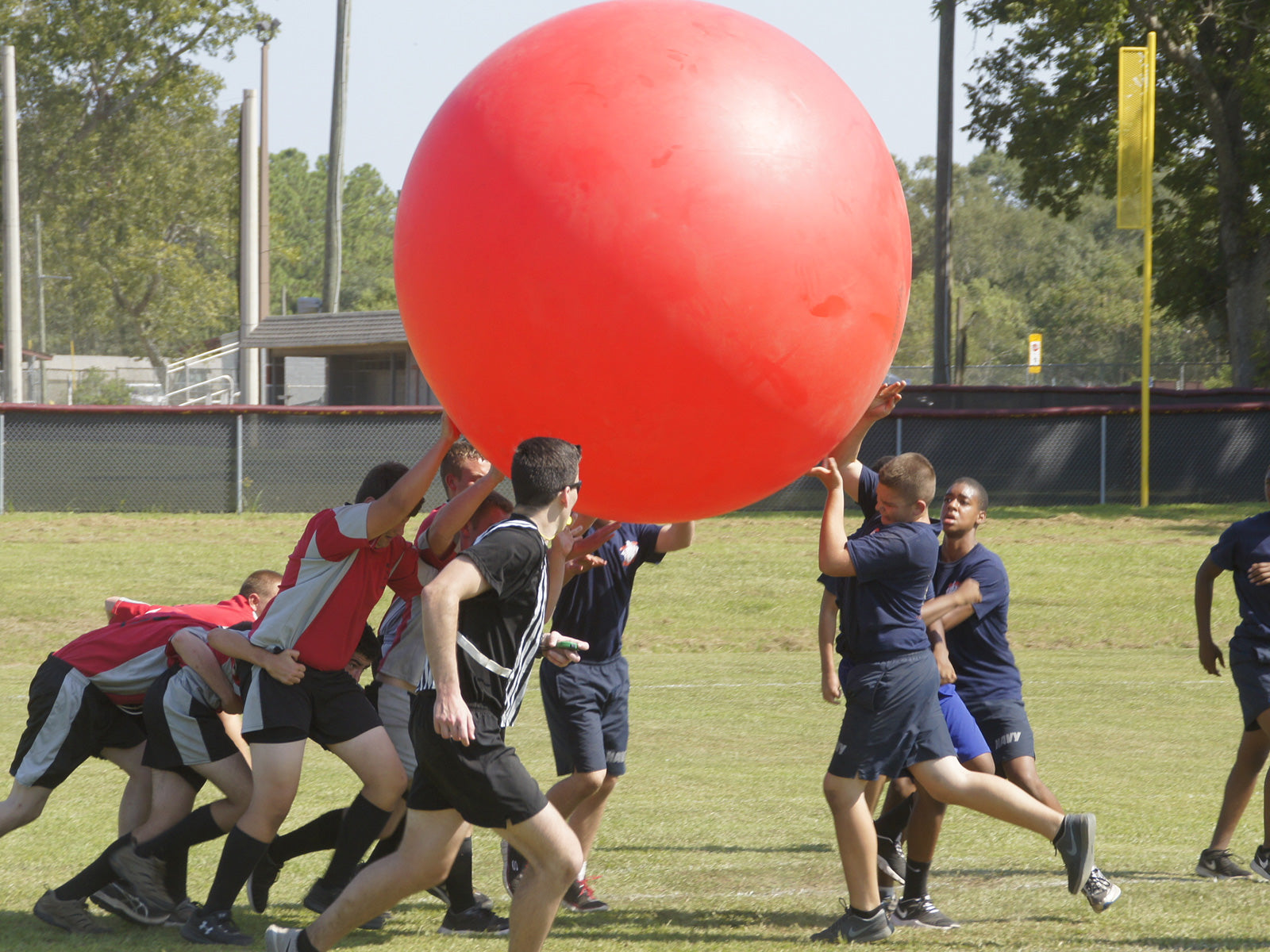 Rugby team playing with a red mega ball