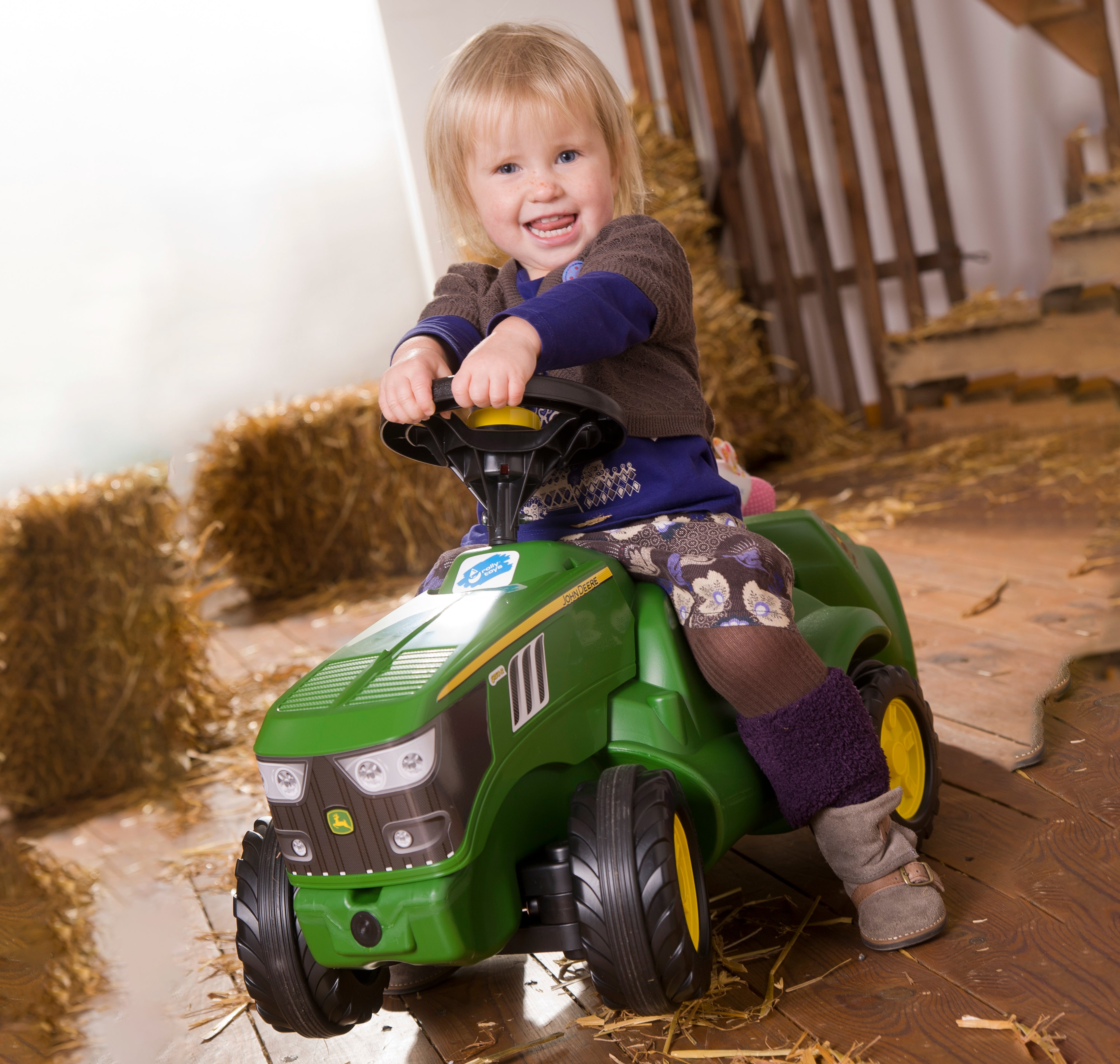 Lifestyle image of toddler sitting on JD made in germany resin ride on vehicle 